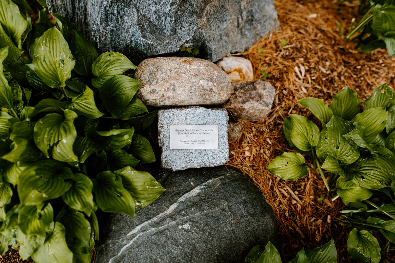 A small stone engraved with the the words "Greater Des Moines Community Foundation Path for Peace"