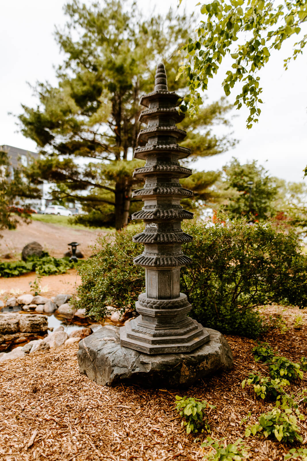 A stone pagoda on a rock within a garden.