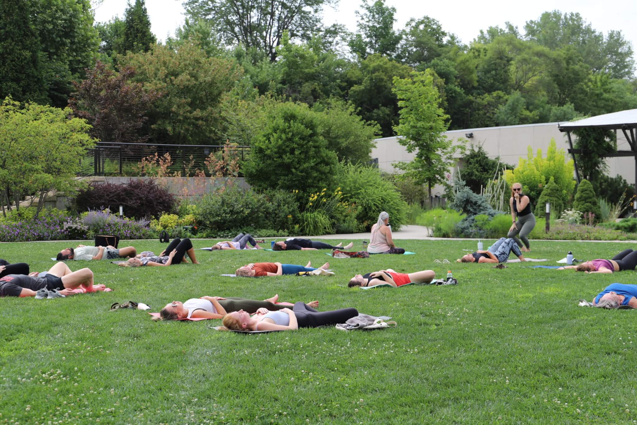 People on the celebration lawn in the Koehn Garden doing yoga.