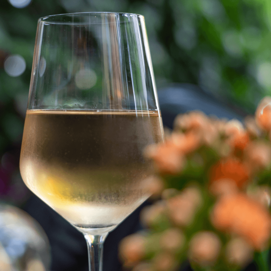 A glass of chilled white wine in a garden. 